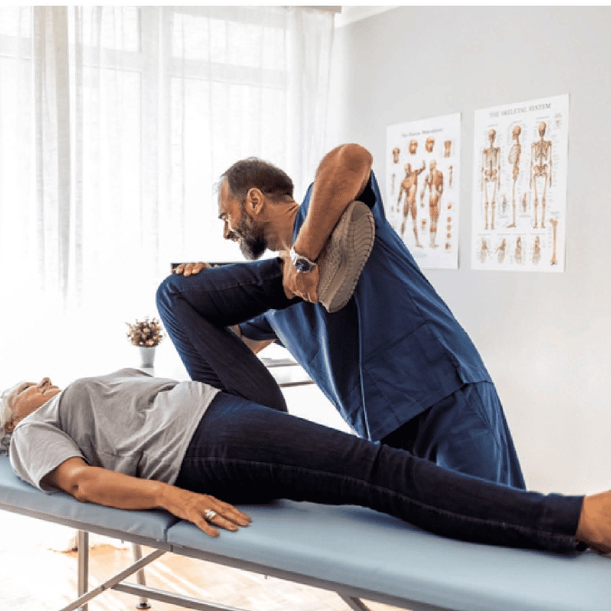 Clinician stretching older patient's leg on table